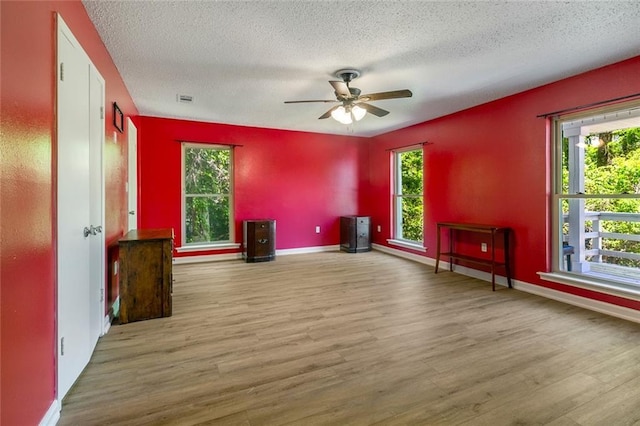 28189 Creole Rd, Lacombe, LA 70445 - empty room with wood finished floors, ceiling fan, a textured ceiling, and baseboards