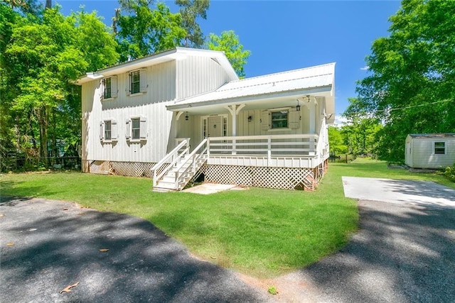 28189 Creole Rd, Lacombe, LA 70445 - view of front of property with covered porch, a front yard, stairs, an outbuilding, and a storage unit