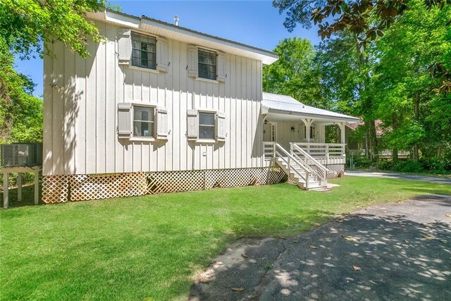 28189 Creole Rd, Lacombe, LA 70445 - view of front of property with covered porch, a front lawn, and board and batten siding