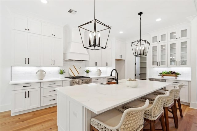 605 Northwoods Dr, Abita Springs, LA 70420 - kitchen featuring a chandelier, a sink, custom exhaust hood, tasteful backsplash, and white cabinetry