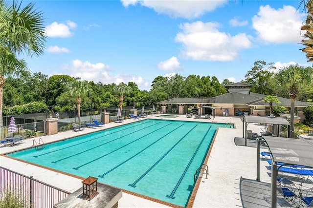 605 Northwoods Dr, Abita Springs, LA 70420 - community pool with fence, view of wooded area, and a patio