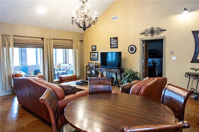 dining area with a chandelier, finished concrete flooring, and high vaulted ceiling