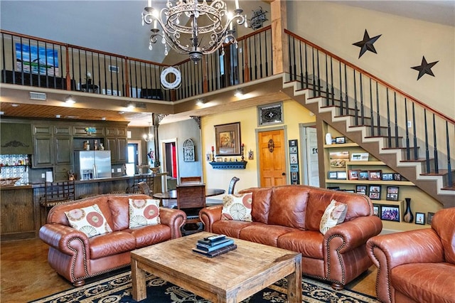 living area with a chandelier, a high ceiling, and stairs