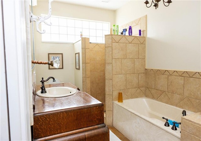 bathroom with a garden tub and vanity