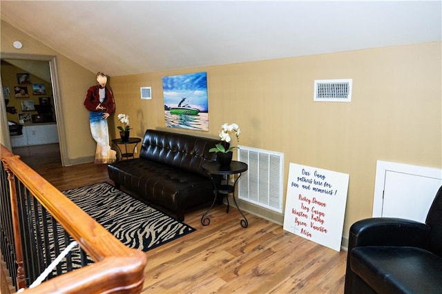 living room with wood finished floors and vaulted ceiling