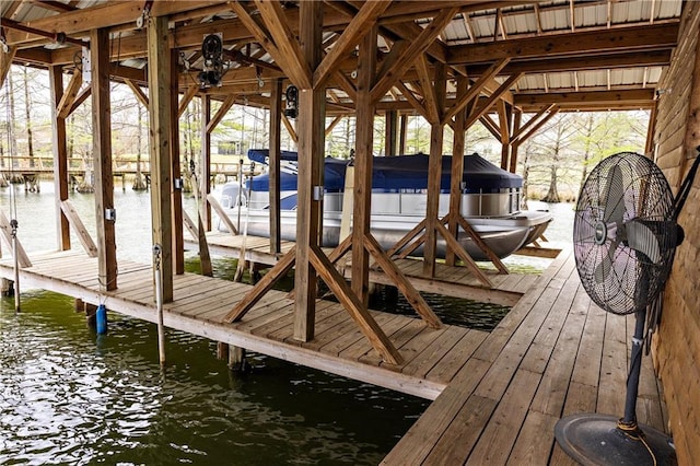 dock area featuring boat lift and a water view