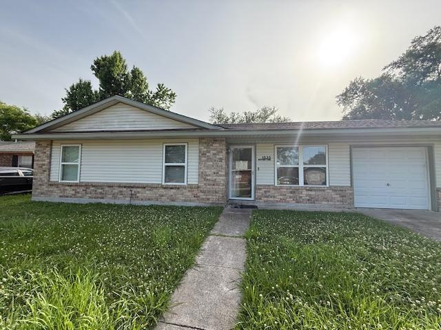 1535 Natchez Ln, La Place, LA 70068 - single story home with brick siding, a garage, a front yard, and driveway