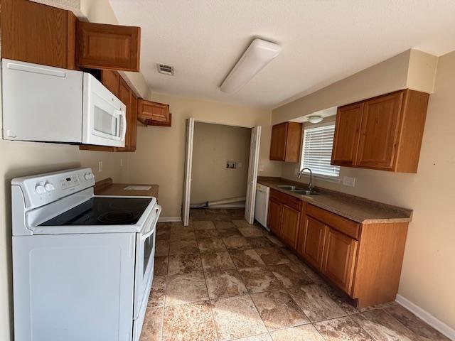 1535 Natchez Ln, La Place, LA 70068 - kitchen with white appliances, a sink, and brown cabinetry