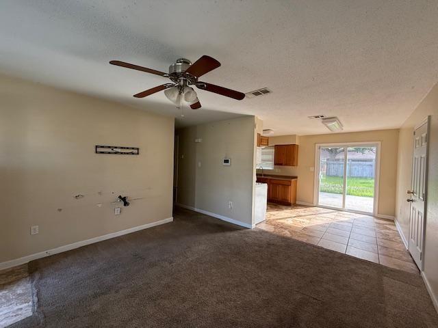 1535 Natchez Ln, La Place, LA 70068 - unfurnished living room with light carpet, a ceiling fan, light tile patterned flooring, baseboards, and a textured ceiling