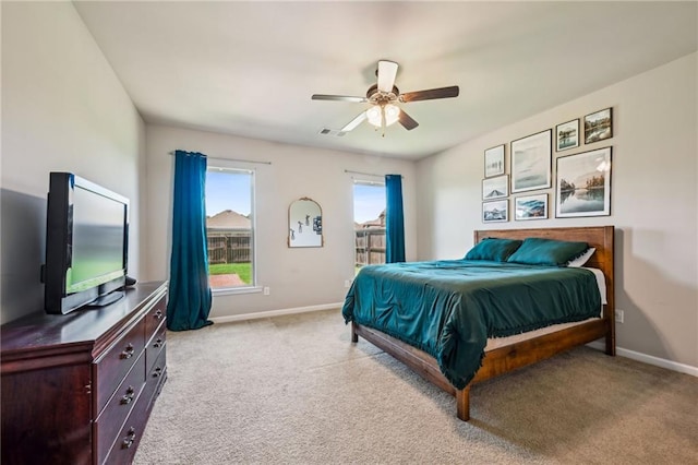 bedroom featuring light carpet, baseboards, and a ceiling fan
