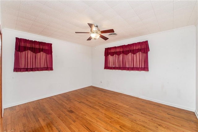 unfurnished room featuring a ceiling fan, ornamental molding, wood finished floors, and baseboards