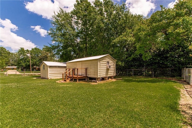 view of yard featuring a storage unit, an outdoor structure, and view of wooded area