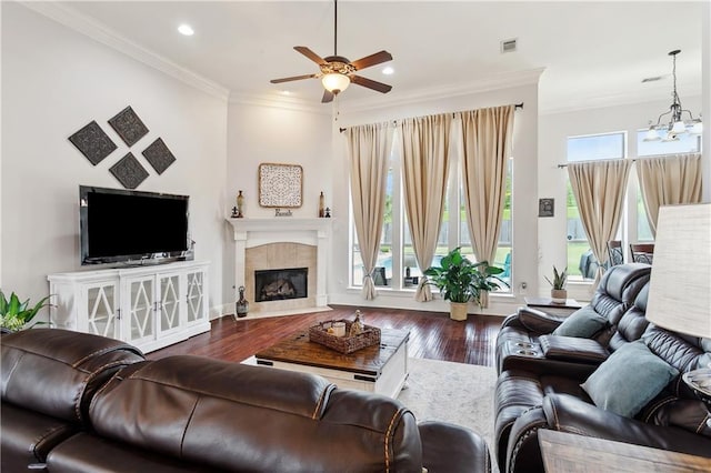 living room with a ceiling fan, wood finished floors, ornamental molding, a tile fireplace, and recessed lighting
