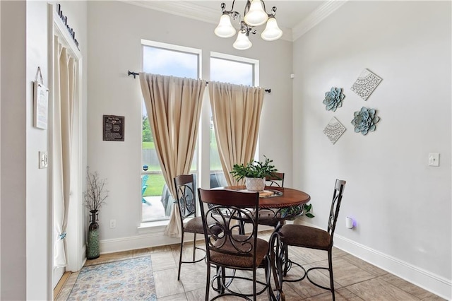 dining room with ornamental molding, plenty of natural light, a chandelier, and baseboards
