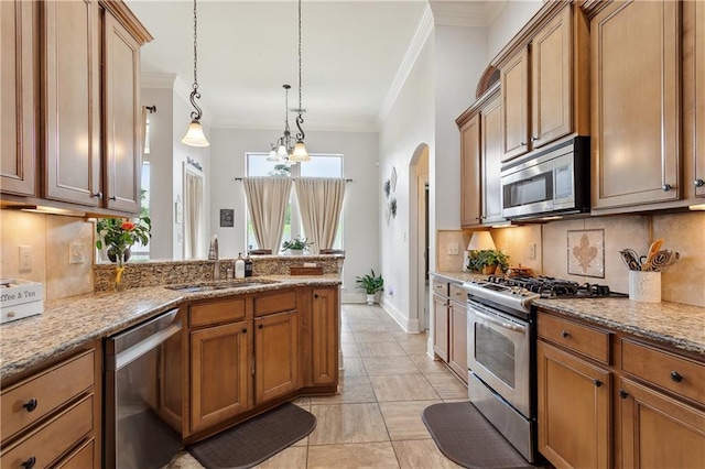 kitchen with stainless steel appliances, crown molding, backsplash, a sink, and arched walkways