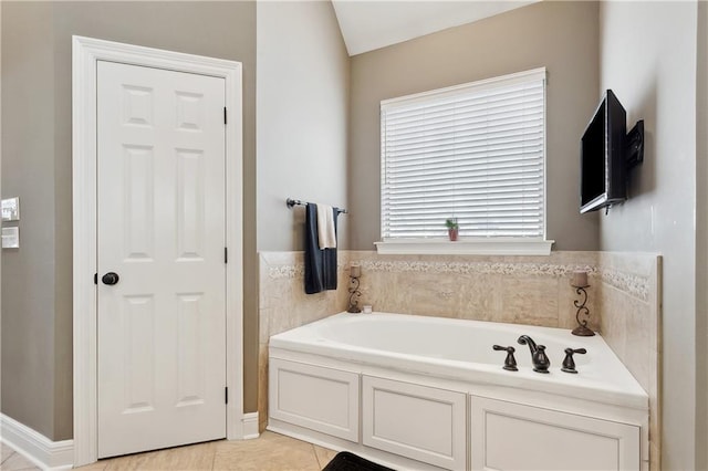 bathroom with a garden tub and tile patterned flooring