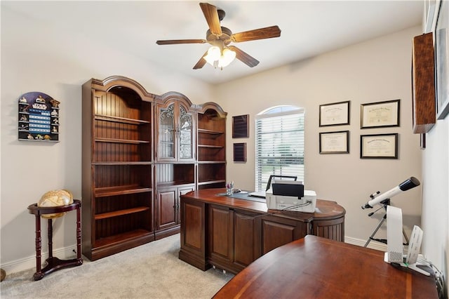 home office featuring ceiling fan, light carpet, and baseboards