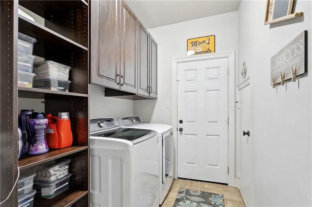 laundry area featuring washing machine and dryer, cabinet space, and light wood-style floors