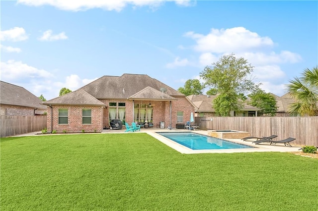 back of property with a patio, brick siding, and an in-ground hot tub