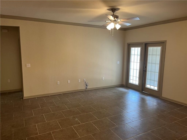 empty room with a ceiling fan, baseboards, crown molding, french doors, and dark tile patterned floors