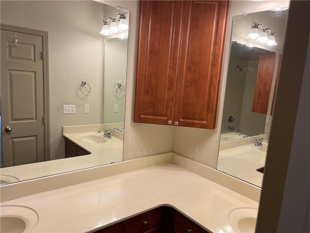 full bath with vanity, shower / bath combination, and a textured wall