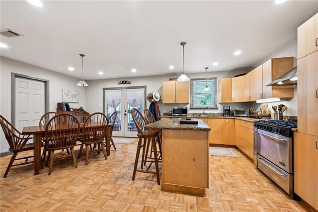389 Hickory Dr, Slidell, LA 70458 - kitchen with appliances with stainless steel finishes, under cabinet range hood, light brown cabinetry, a kitchen island, and recessed lighting
