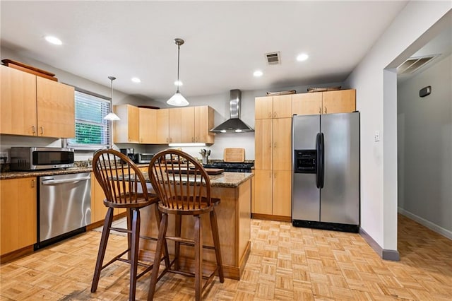 389 Hickory Dr, Slidell, LA 70458 - kitchen featuring stainless steel appliances, wall chimney exhaust hood, light brown cabinetry, a center island, and baseboards