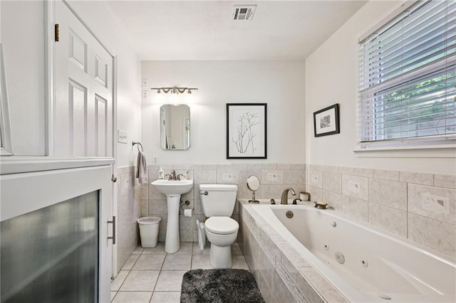 389 Hickory Dr, Slidell, LA 70458 - full bath with toilet, a whirlpool tub, tile patterned floors, a wainscoted wall, and a sink