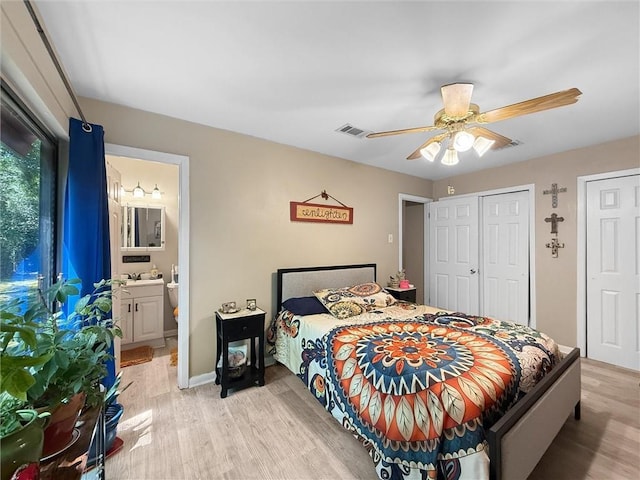 58207 Jefferson Ave, Slidell, LA 70460 - bedroom featuring light wood finished floors, a ceiling fan, ensuite bathroom, two closets, and baseboards