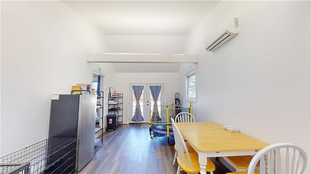 dining space featuring french doors, a wall mounted AC, and wood finished floors