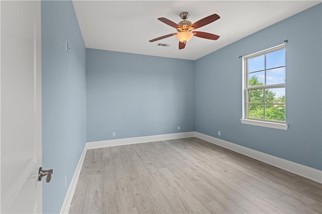 spare room with wood finished floors, ceiling fan, and baseboards