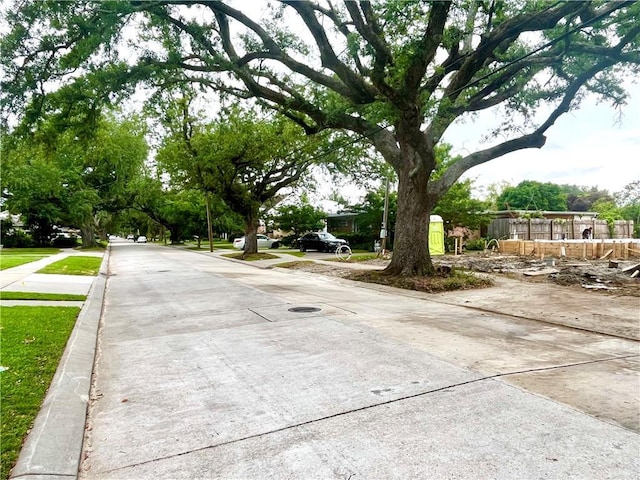 view of concrete road with curbs