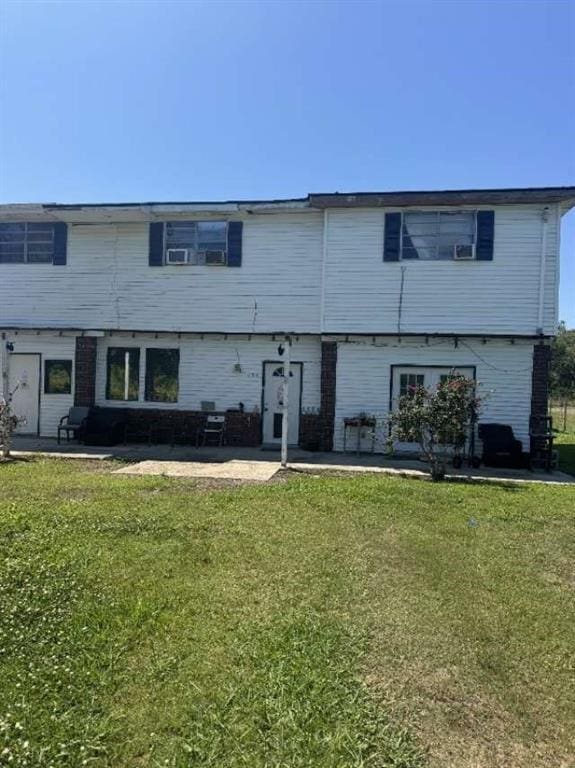 townhome / multi-family property with a patio and a front yard