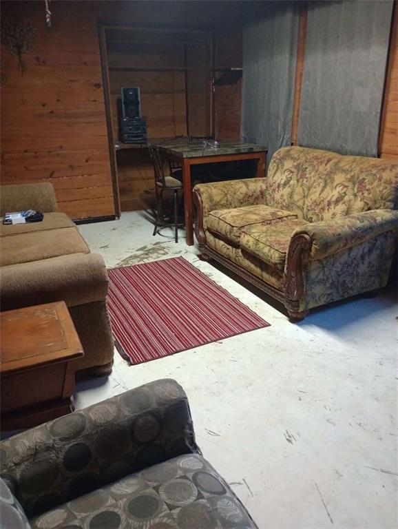 living room with concrete floors and wood walls