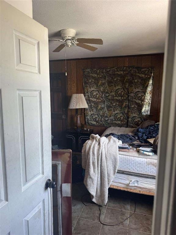 tiled bedroom with a textured ceiling and a ceiling fan