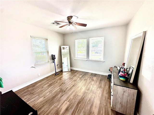 spare room with ceiling fan, wood finished floors, and baseboards