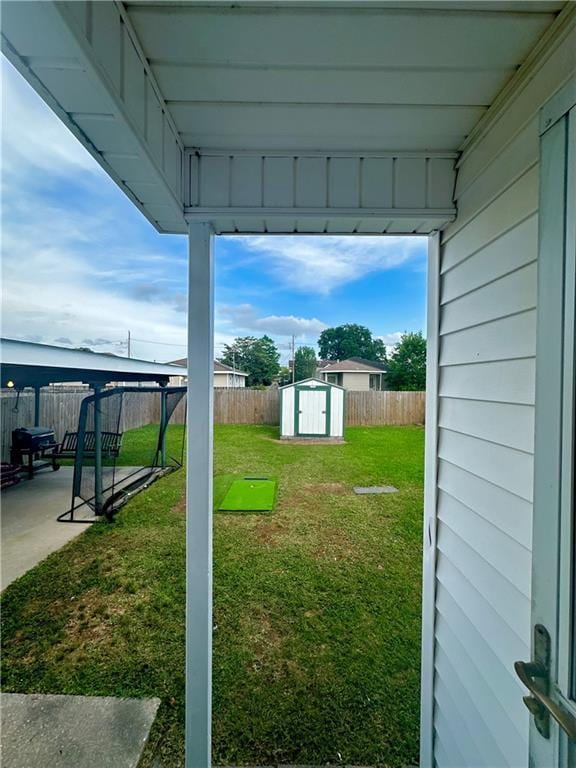 view of yard featuring a storage unit, an outdoor structure, and a patio area