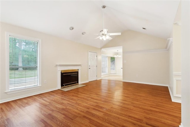 unfurnished living room with a ceiling fan, a chandelier, a fireplace with flush hearth, wood finished floors, and high vaulted ceiling