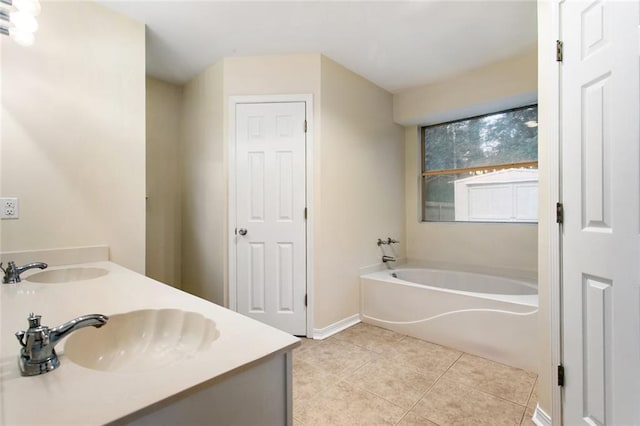 bathroom featuring tile patterned floors, a bath, double vanity, and baseboards