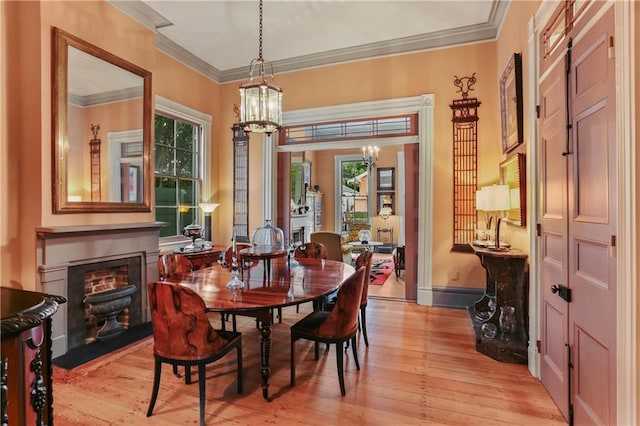 dining space featuring a chandelier, plenty of natural light, light wood-style flooring, and crown molding