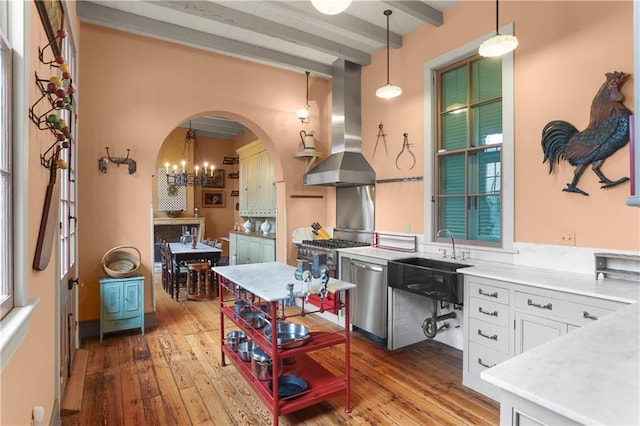 kitchen featuring extractor fan, stainless steel dishwasher, beam ceiling, light wood-style flooring, and a sink