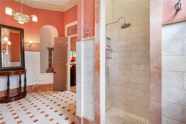 bathroom with tiled shower, crown molding, and tile walls
