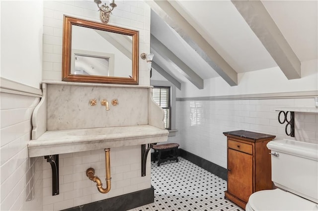 half bathroom with tile walls, beam ceiling, and toilet
