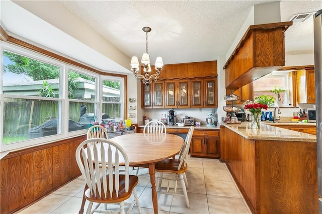 5037 Tartan Dr, Metairie, LA 70003 - dining area with light tile patterned floors, a chandelier, and a textured ceiling