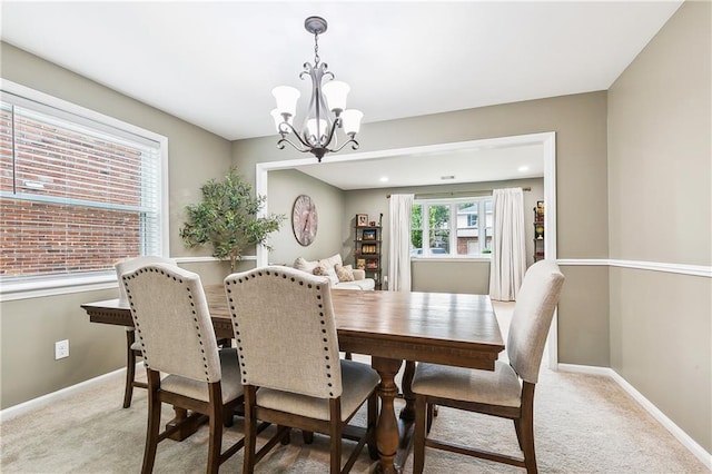 5037 Tartan Dr, Metairie, LA 70003 - dining area featuring a chandelier, light colored carpet, and baseboards