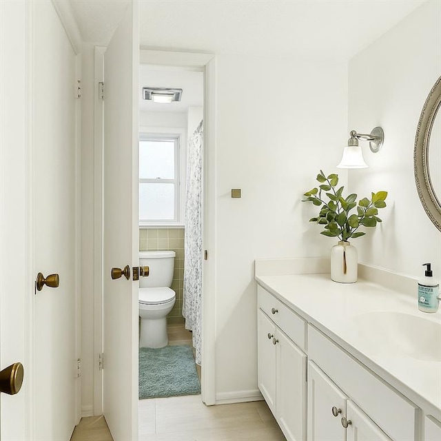 5037 Tartan Dr, Metairie, LA 70003 - full bathroom featuring toilet, vanity, and tile walls