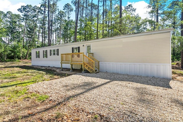 25259 Bunker St, Abita Springs, LA 70420 - back of property featuring a wooden deck and view of scattered trees