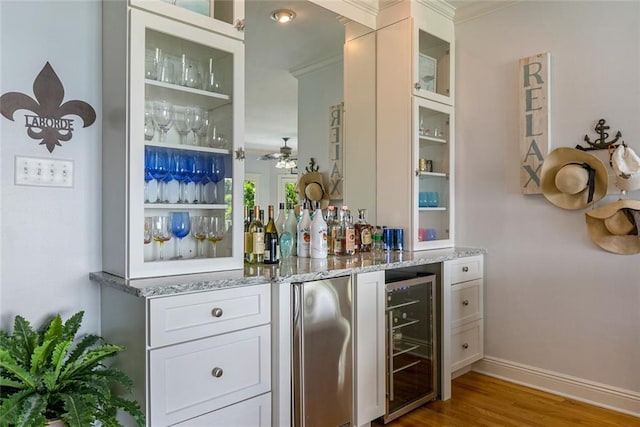 228 Marlin Dr, Slidell, LA 70461 - indoor dry bar featuring beverage cooler, wood finished floors, crown molding, ceiling fan, and baseboards
