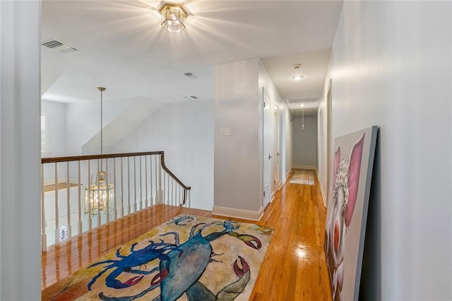 228 Marlin Dr, Slidell, LA 70461 - hallway with light wood finished floors, attic access, a chandelier, and baseboards