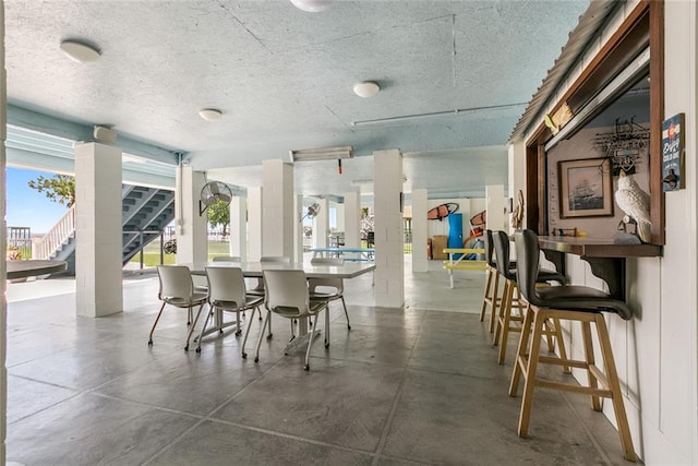 228 Marlin Dr, Slidell, LA 70461 - dining room featuring a textured ceiling, concrete flooring, and stairs